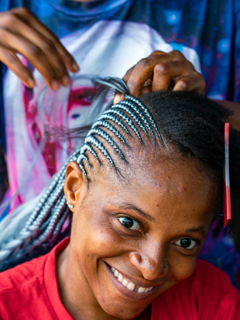 Client smiling while getting cornrows